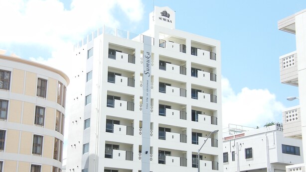 A multi-story building with balconies, a sign reading "SUMUKA", and a sign for "Hair Face". - SUMUKA Shintoshin II (Naha)