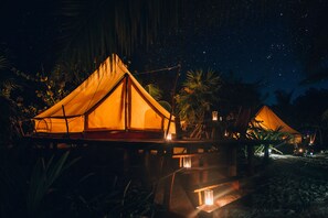 A tented accommodation with a starry night sky, surrounded by tropical vegetation. - Glamp Ikal Tulum (Tulum)