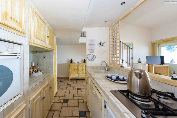 A kitchen with wooden cabinets, a tiled backsplash, a stove, and a sink.