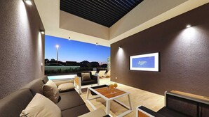 A modern living room with a pool view, a framed sign on the wall, and a wooden coffee table. - Villa Lana - Home4You (Kraj)