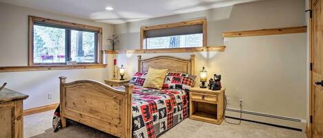 A bedroom with a wooden bed, two bedside tables, a window, and a built-in shelf.