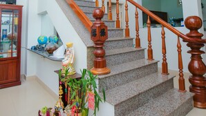 Una escalera con barandillas de madera y un farol rojo.