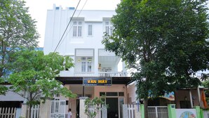 Un edificio con un letrero que dice 'VAN MAY Homestay' en la entrada.