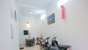 Habitación limpia y bien iluminada con comedor, espejo y varias scooters estacionadas contra la pared.