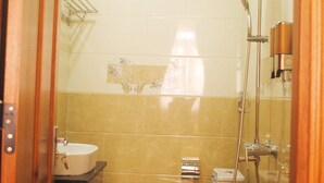 A small bathroom with a toilet, sink, and shower.