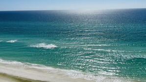 A beach with clear blue water and a sandy shore.