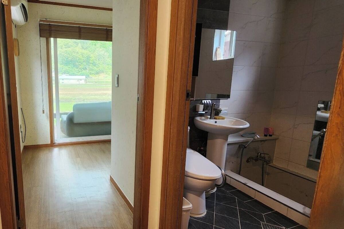 Une salle de bain avec des toilettes, un lavabo et une douche.