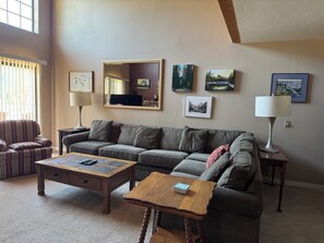 A living room with a sofa, two coffee tables, and a television.