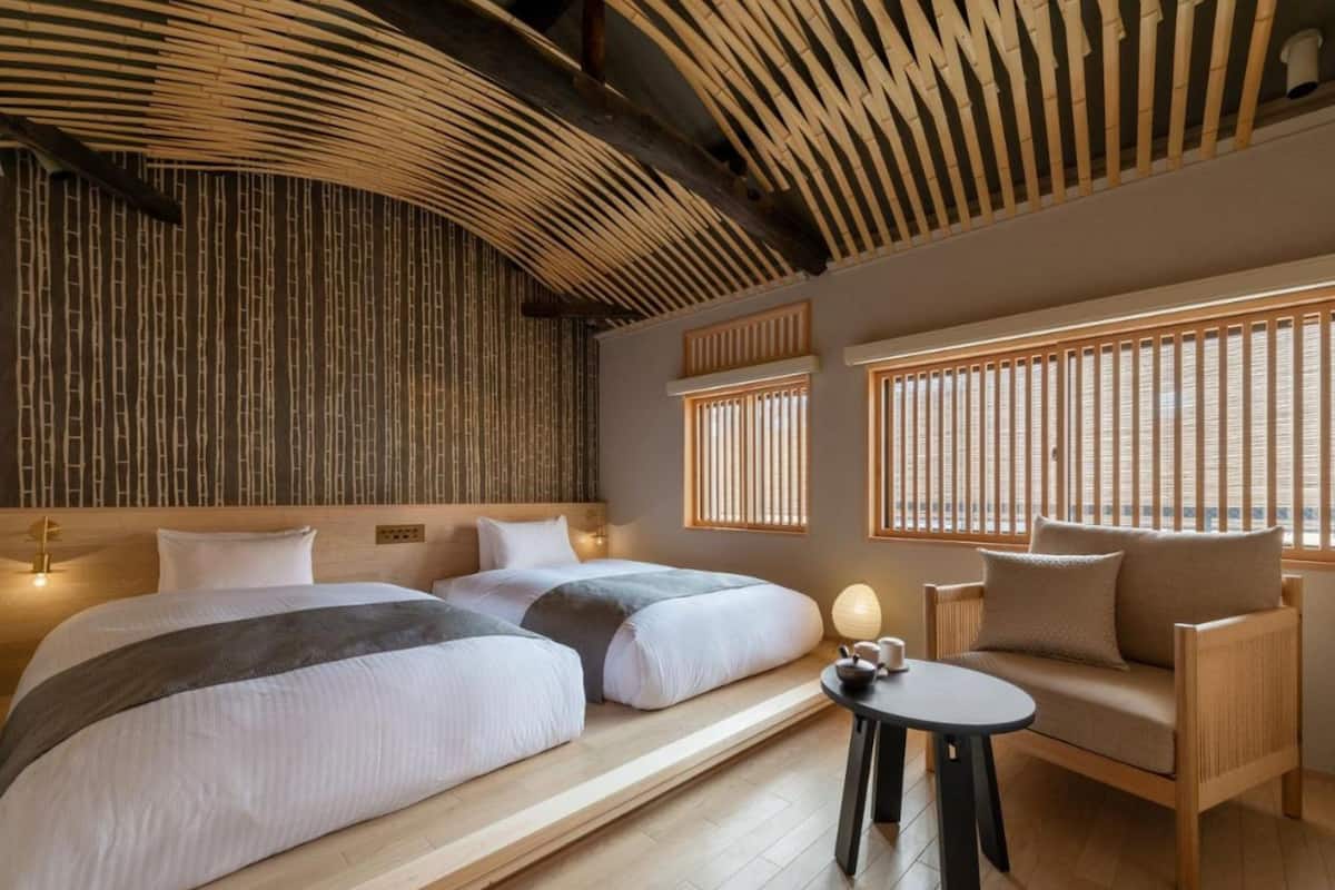 A room with two beds, a sofa, and a small table.
