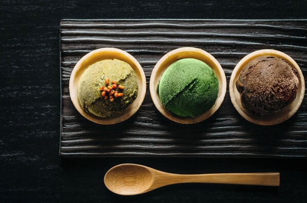 Three bowls of matcha on a dark wooden surface.