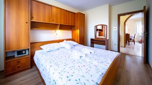 A bedroom with a bed, wooden wardrobe, bedside table, and a mirror. - Apartment in Lopar with Balcony, Air condition, WIFI, Washing machine (4886-2) (Lopar)