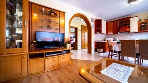 A living room with a TV, wooden cabinets, and a glass coffee table. - Apartment in Lopar with Balcony, Air condition, WIFI, Washing machine (4886-2) (Lopar)