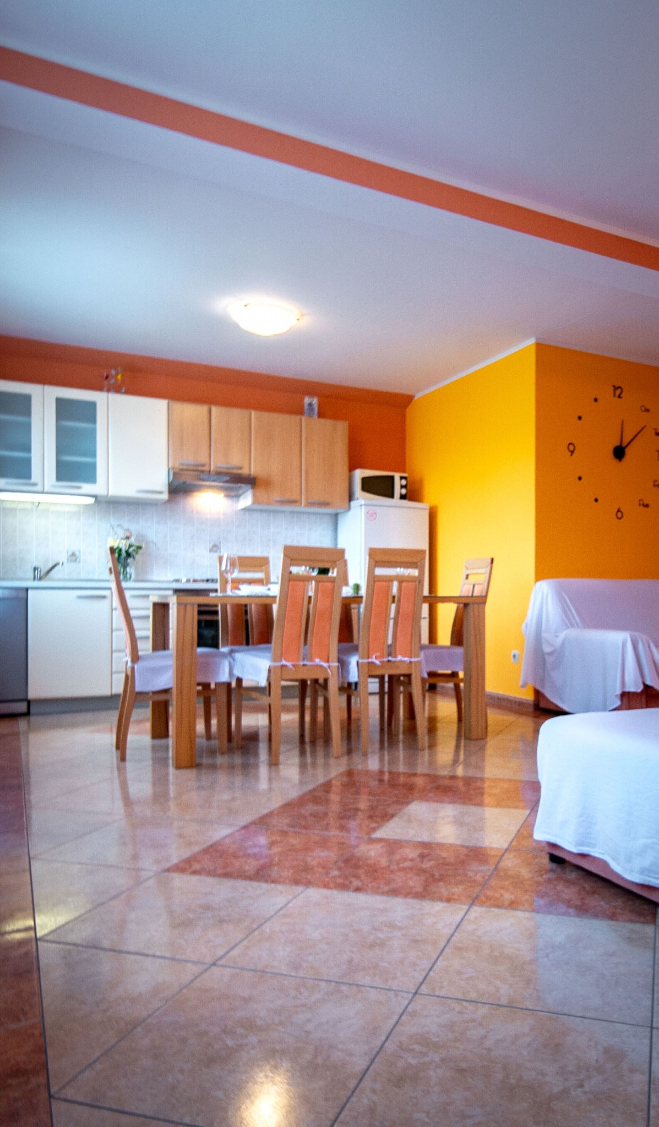 Un espace de vie compact comprenant un coin repas, une kitchenette et un lit.