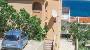 Un edificio con tetto in tegole rosse, un'antenna parabolica e un'auto parcheggiata davanti.