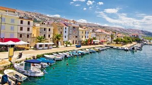 A coastal town with colorful buildings, a marina with boats, and a clear blue sky. - Apartment in Pag with Seaview, Terrace, Air condition, WIFI (4891-2) (Pag)