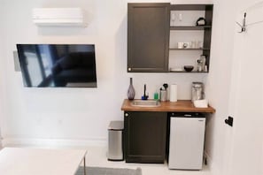 A compact kitchen with a built-in dishwasher, a small sink, and a microwave.
