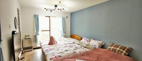 Un dormitorio con cama, escritorio, silla, ventana con cortinas y lámpara en el techo.