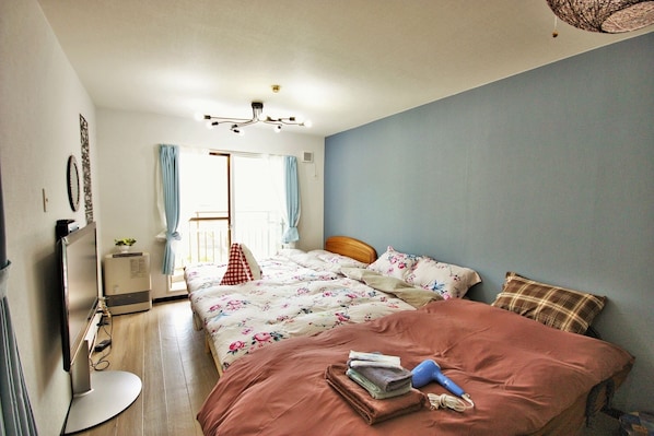A bedroom with a bed, a desk, a chair, a window with curtains, and a ceiling light fixture.