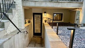 A concrete staircase leading to a door with a glass panel, flanked by two wall-mounted lights and a small window. - No More Looking-Parking (Washington)
