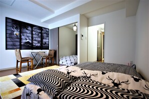 A bedroom with a bed, a desk, and a chair. There is a painting on the wall and a door leading to another room. - Irios 302 Susukino (Sapporo)