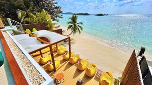 A deck with a wooden floor, yellow bean bags, and a white canopy. - The Stay Chaweng Beach Resort (Koh Samui)
