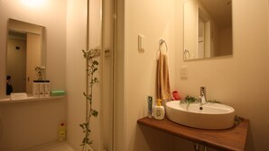 Un baño con lavabo, espejo y artículos de aseo.