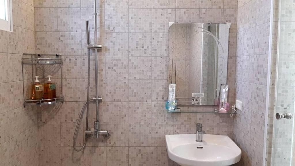 A bathroom with a shower, a sink, and a mirror.