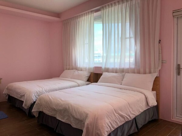 A bedroom with two beds, pink walls, and sheer curtains. - Ding Dong Homestay (Hengchun)