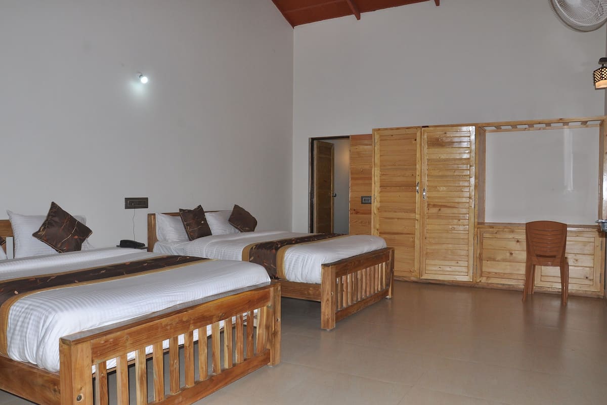 Ein Zimmer mit zwei Holzbetten, einem Schreibtisch aus Holz und einem Stuhl.