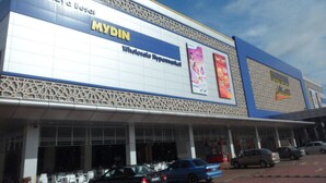 Una tienda MYDIN con un letrero grande y fachada azul y blanca.