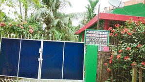 A gated property with a signboard indicating a home stay. - Kaziranga   homestay (Kohora)