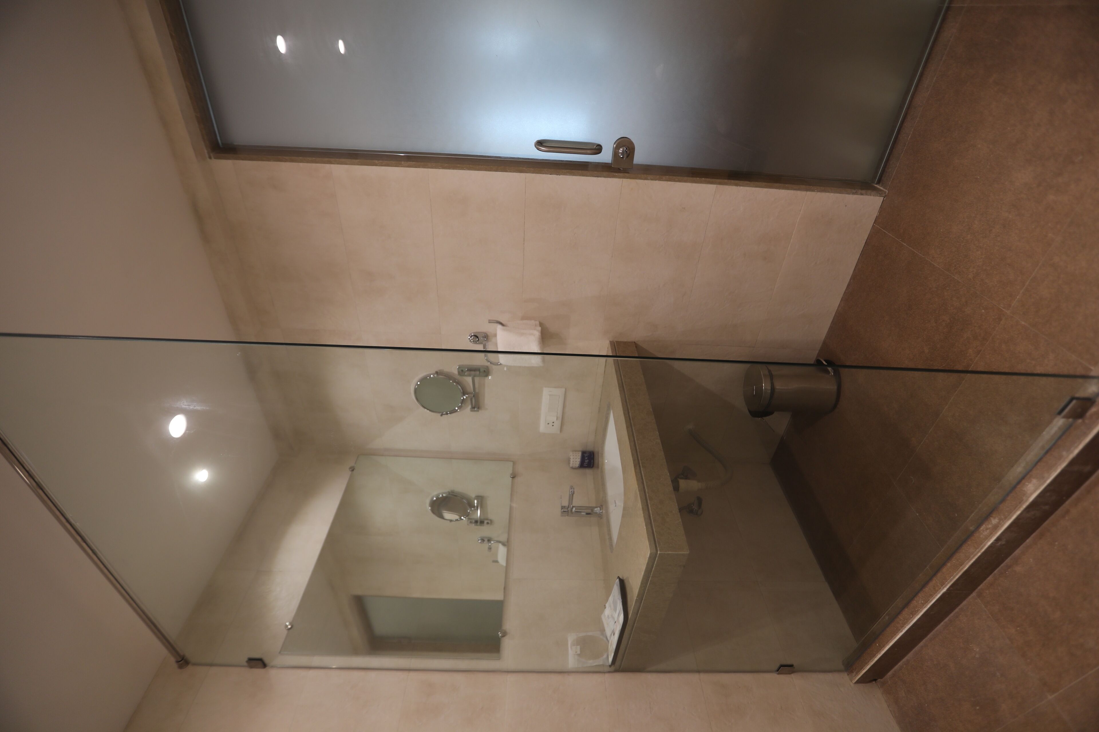 A modern bathroom with a glass shower enclosure, a toilet, and a sink.