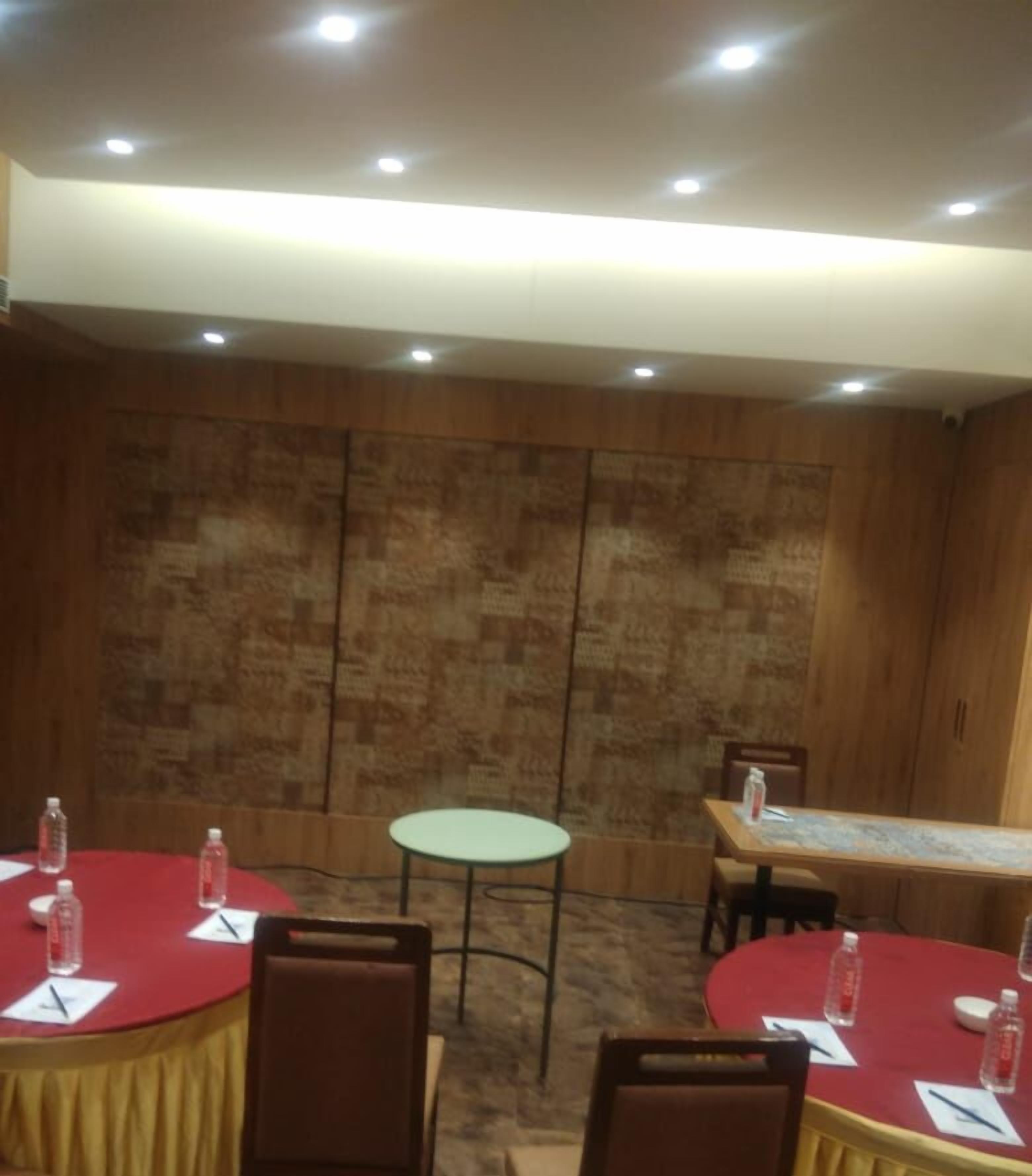A conference room with round tables, chairs, and a small round table.
