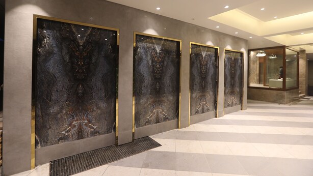 A hallway with marble wall panels and a checkered floor. - Hotel Cliffton (Mumbai)