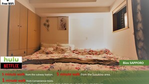 Une chambre à coucher avec un lit, une armoire et des œuvres d’art accrochées au mur.