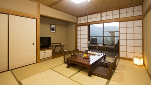 Ein traditioneller japanischer Raum mit Tatami-Boden, einem niedrigen Holztisch und einer Schiebetür.