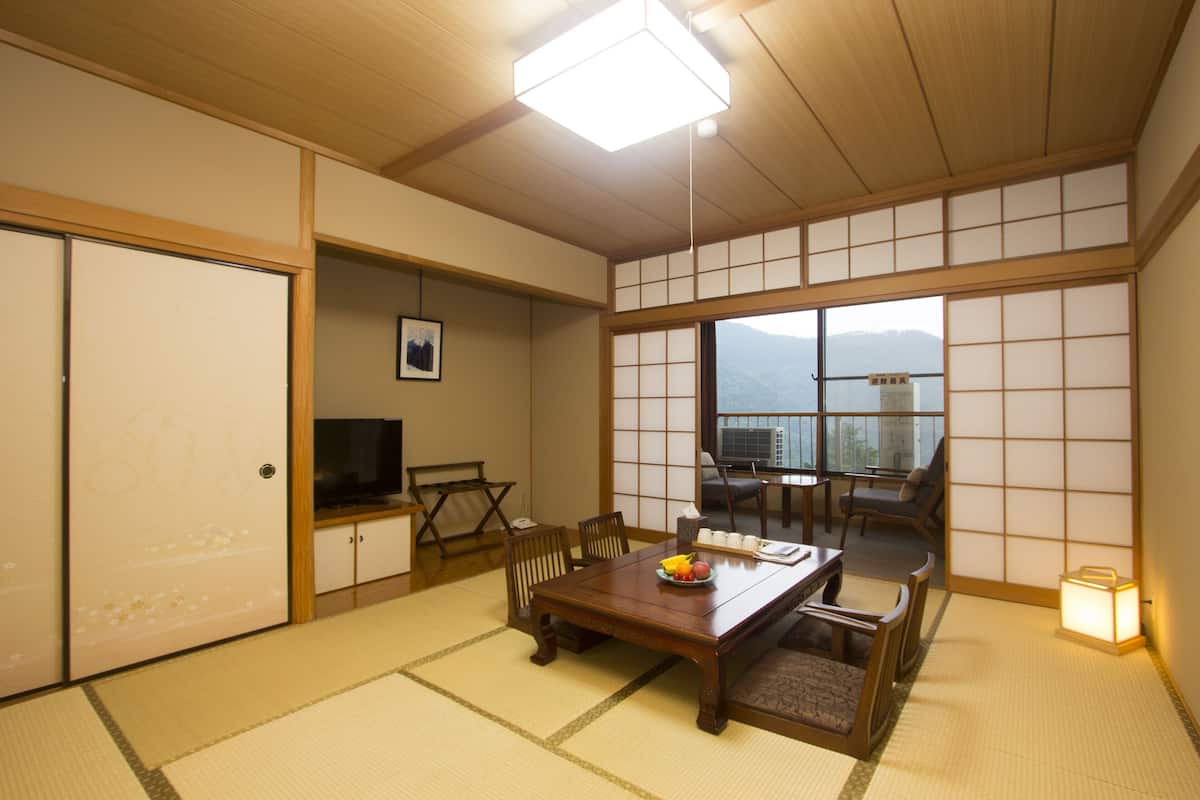 Ein traditioneller japanischer Raum mit Tatami-Boden, einem niedrigen Holztisch und einer Schiebetür.
