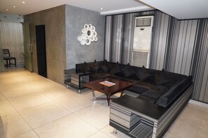 Una sala de estar moderna con un sofá seccional, una mesa de centro y un adorno colgando en la pared.