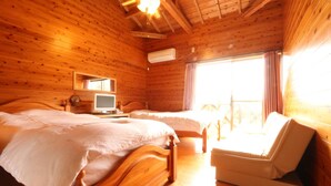 A wooden cabin room with two beds, a desk with a computer, and a chair. - Rest and Lodge Syou (Amami)