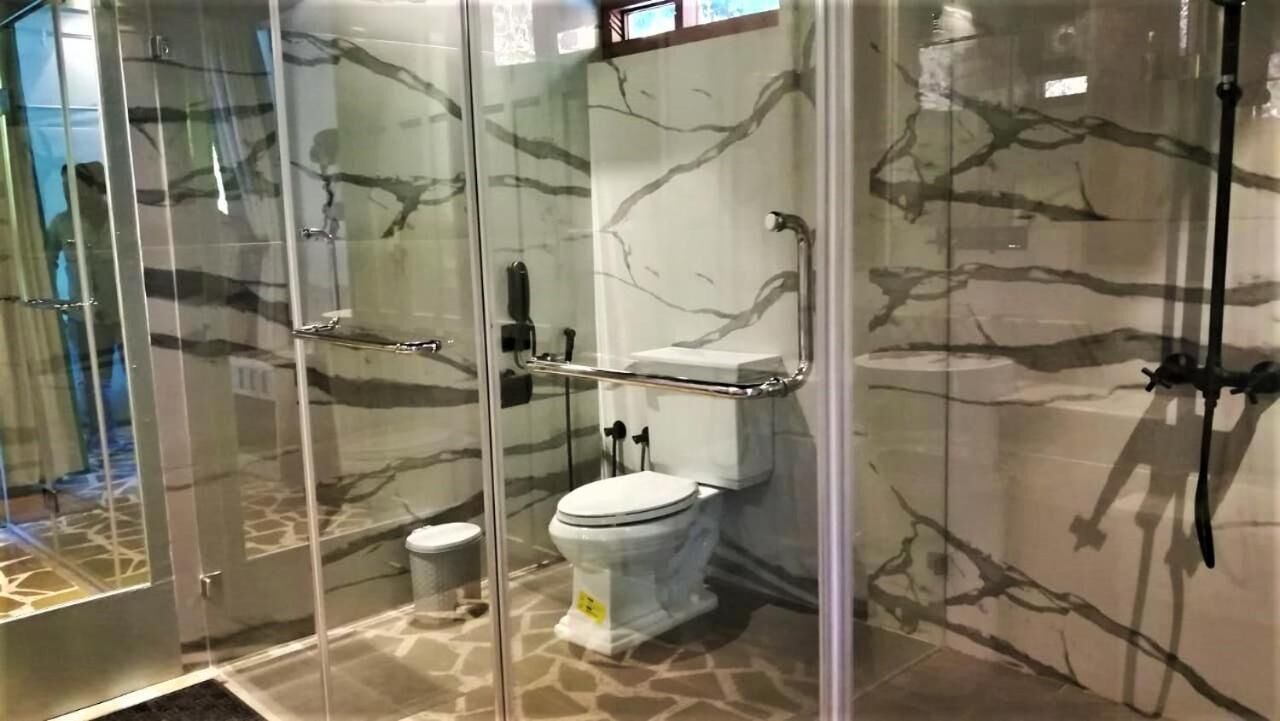 A bathroom with a glass-enclosed shower, a toilet, and a bidet.
