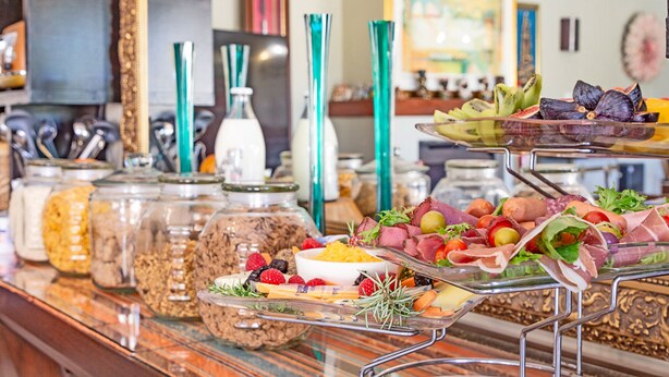 Un bufet amb diversos aliments, com ara fruita, formatges i carns.