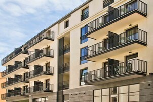 A multi-story hotel with balconies, large windows, and a modern architectural design.