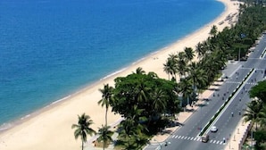 A coastal road with a beach and palm trees. - Santa Luxury Hotel (Da Nang)