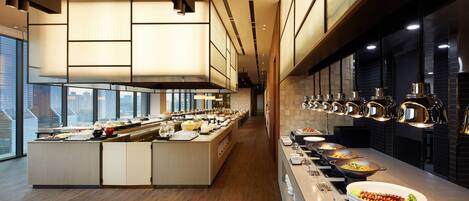 A modern buffet setup with multiple food stations and a central island.