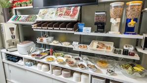A buffet setup with various food items and condiments. - Sejour Inn Nagarekawa (Hiroshima)