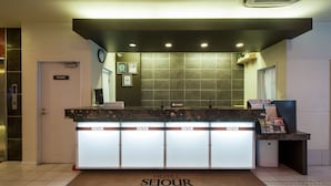 A hotel reception desk with a sign reading "HOTEL SEJOUR INN NAGAREKAWA" and a "PRIVATE" door to the left. - Sejour Inn Nagarekawa (Hiroshima)