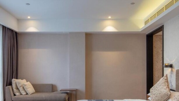 Une chambre à coucher moderne avec un lit, un canapé et une table de chevet.