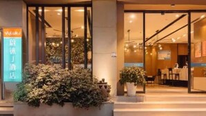 L’entrée d’un hôtel, avec une enseigne indiquant « Luk J » et une autre signalant la présence d’un restaurant.