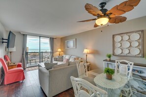 A modern living room with a sofa, chairs, a dining table, and a ceiling fan. - Walk to Family Kingdom, Ocean: Myrtle Beach Condo! (Myrtle Beach)