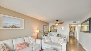 Ein Wohnzimmer mit zwei Sofas, einem Couchtisch, einem Deckenventilator und einem Essbereich mit Tisch und Stühlen.